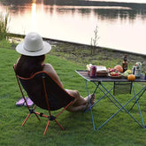 femme-assise-chaise-de-camping-pres-lac