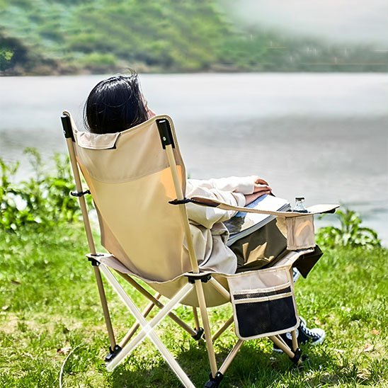 femme-sur-chaise-de-camping-allonge-pres-lac