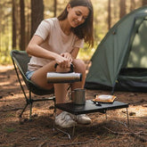 femme verse eau dans cafe sur table pliante de camping